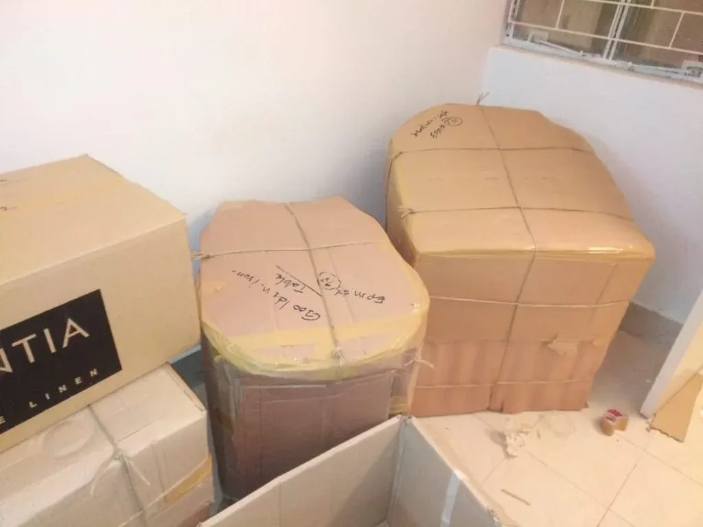 Furniture wrapped in protective sheet and corner-guarded, ready for shifting